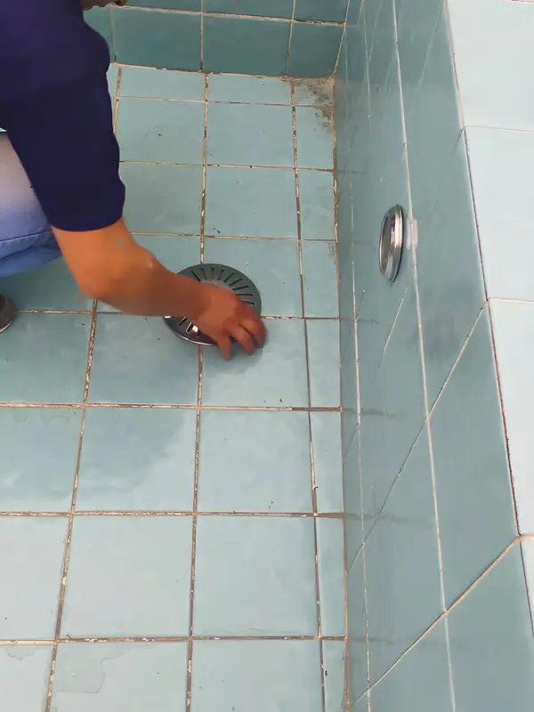 Ralo de fundo da piscina: Inspeção do ralo de uma piscina vazia, ponto comum de perda de água.