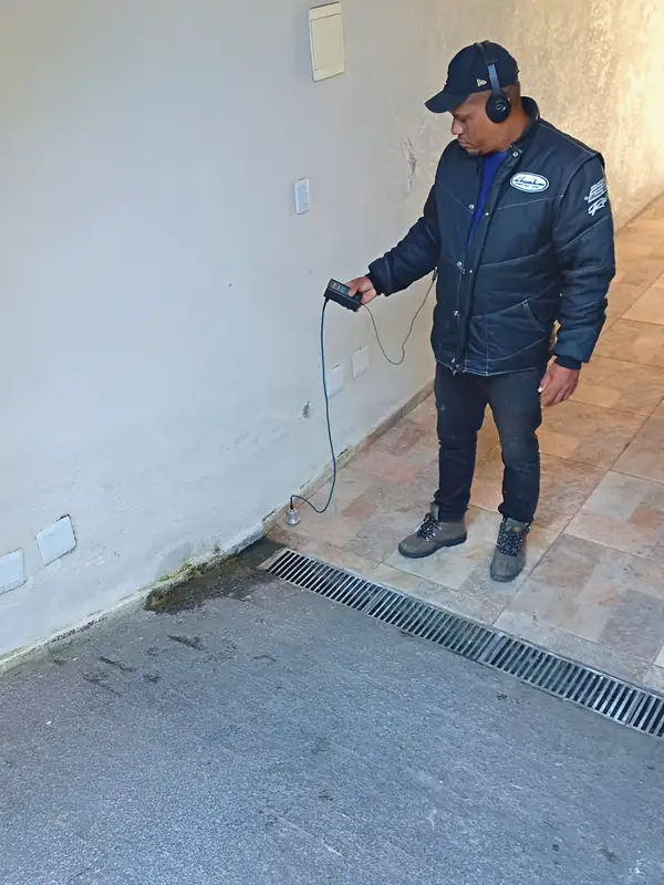 Varredura na área externa: Técnico percorre o piso com o geofone até achar o ponto de maior ruído.